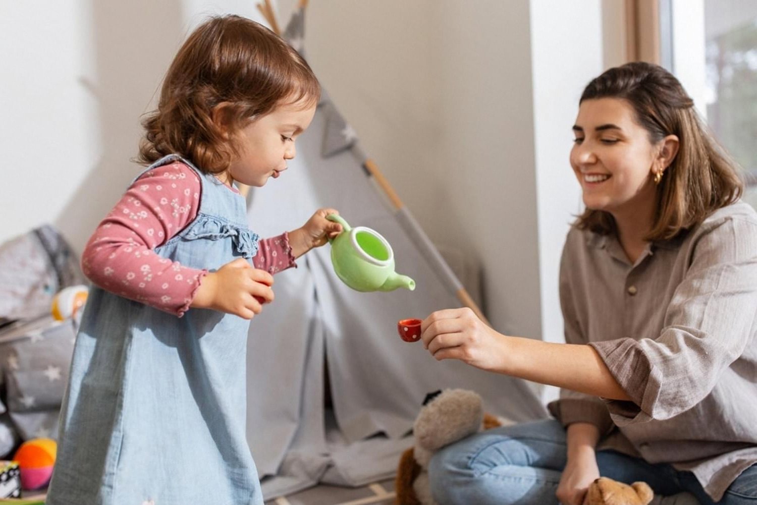 Toddler and mother playing with a pretend tea set inside a UAE home playroom