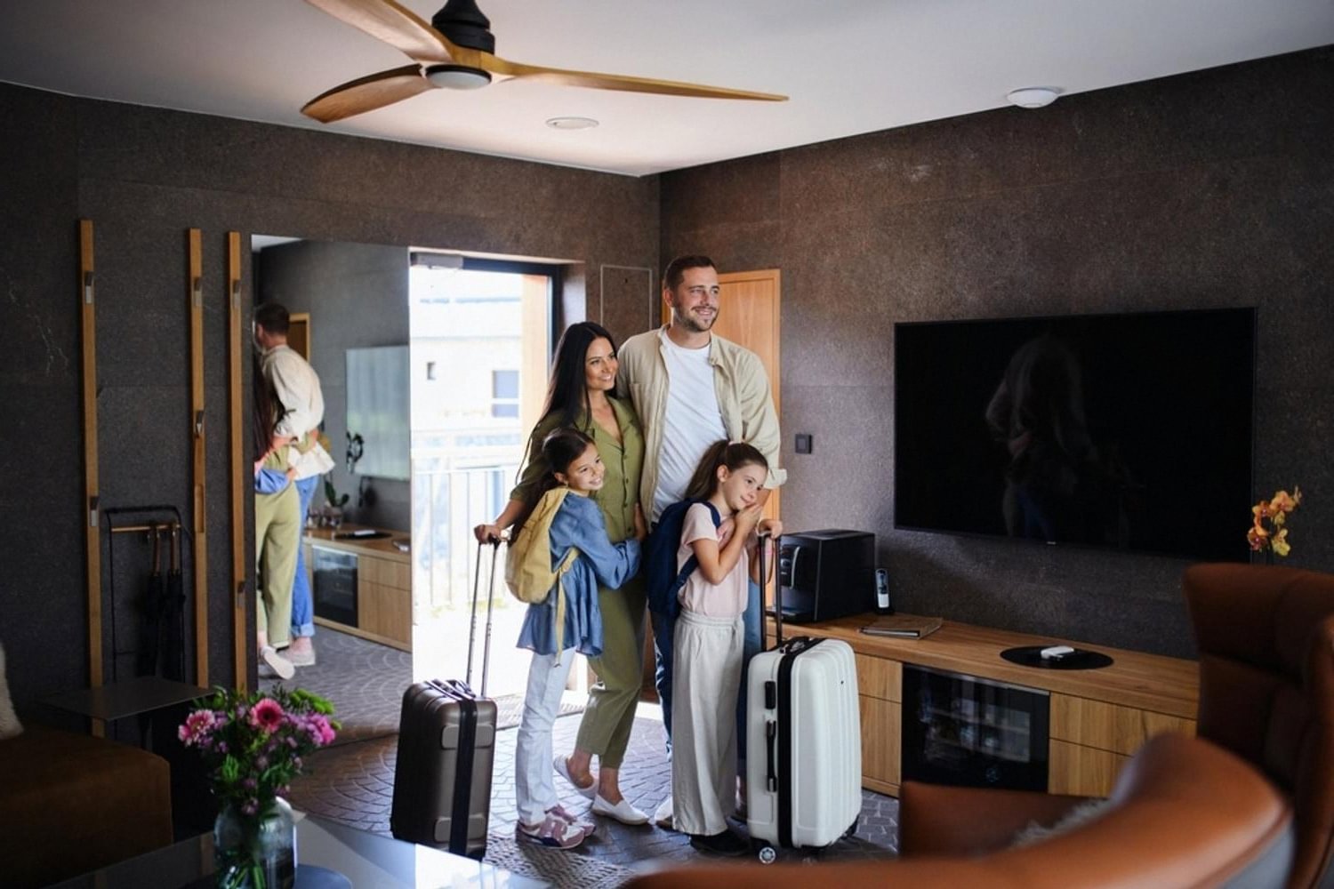 Family with luggage entering a hotel room after using mobile check-in