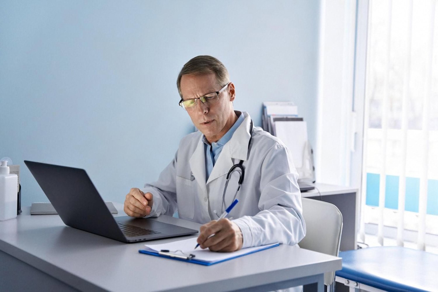 Doctor at a desk reviewing medical insurance paperwork on a laptop in Dubai