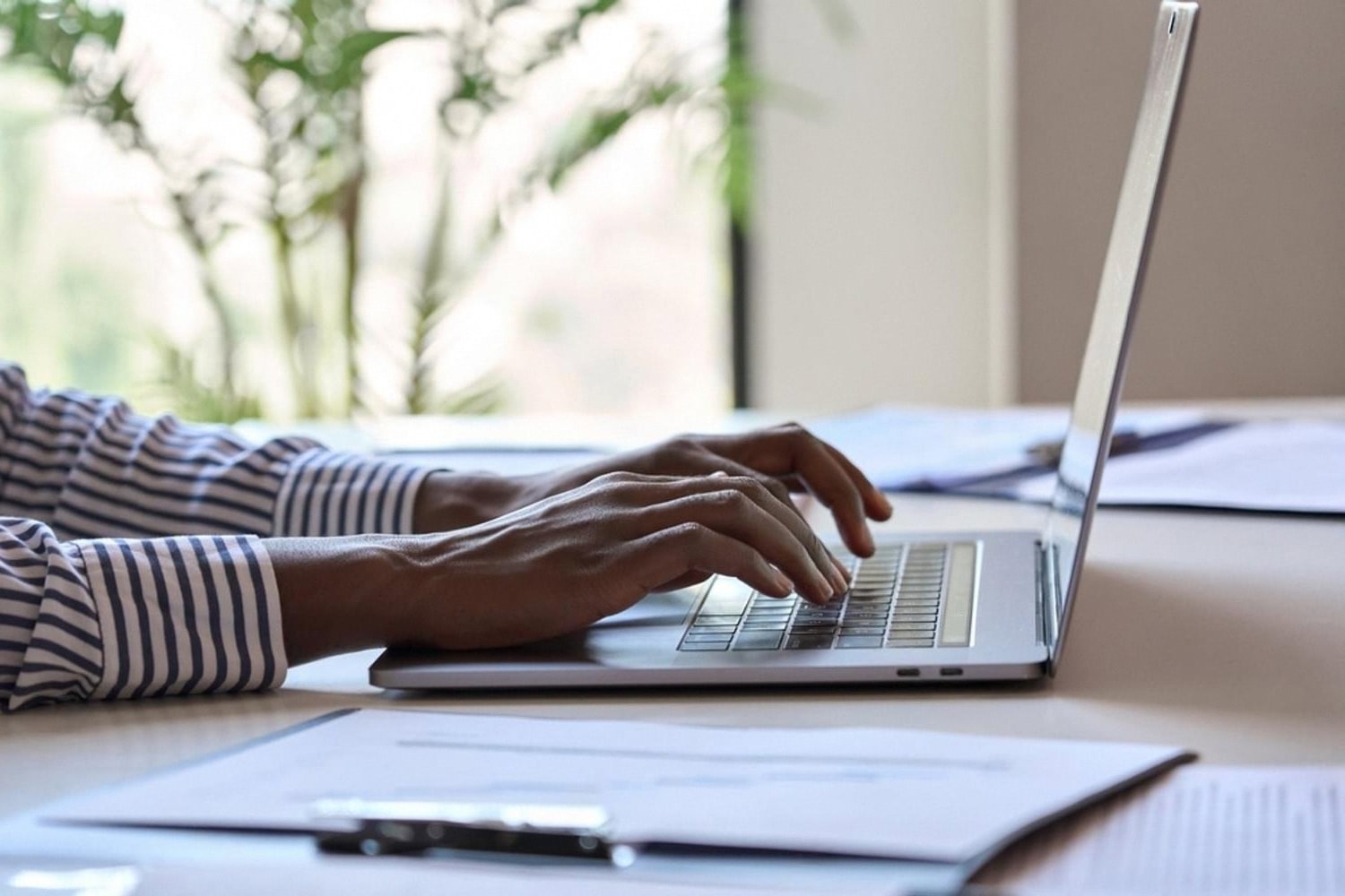 Person typing on a laptop while registering a domain name in the UAE
